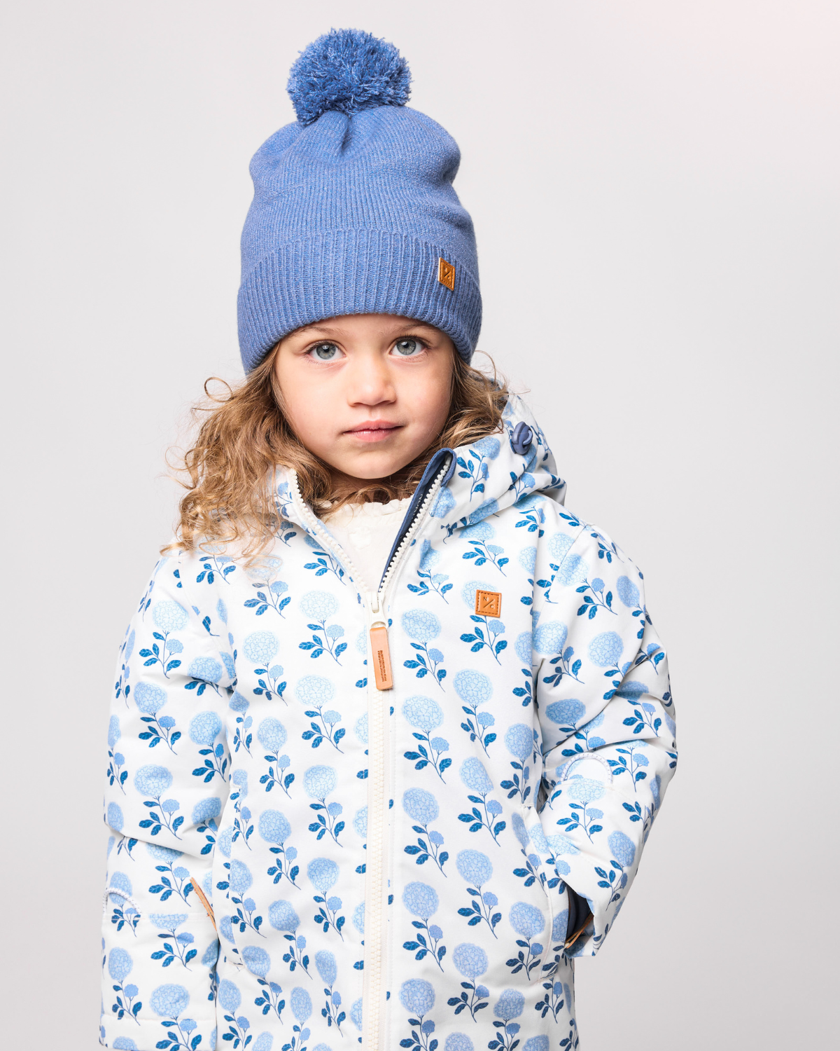 Classic Knit Pom Pom Hat for Kids and Women’s sizes in blue crafted with soft knit fabric, luxe faux fur pom detail, and winter-ready durability for everyday adventures. It's so soft it feels like cashmere.