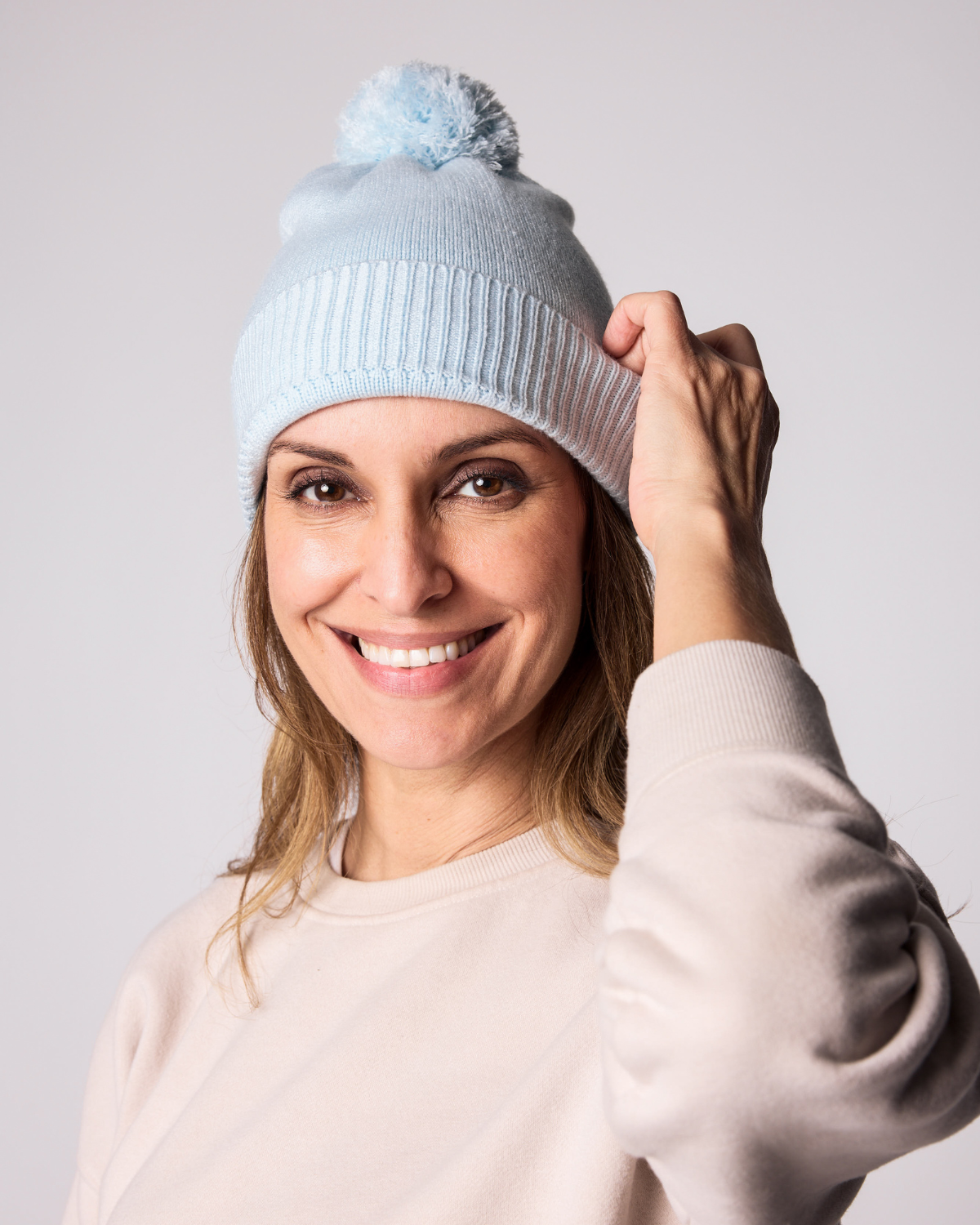 Classic Knit Pom Pom Hat for Kids and Women’s sizes in light blue crafted with soft knit fabric, luxe faux fur pom detail, and winter-ready durability for everyday adventures. It's so soft it feels like cashmere.