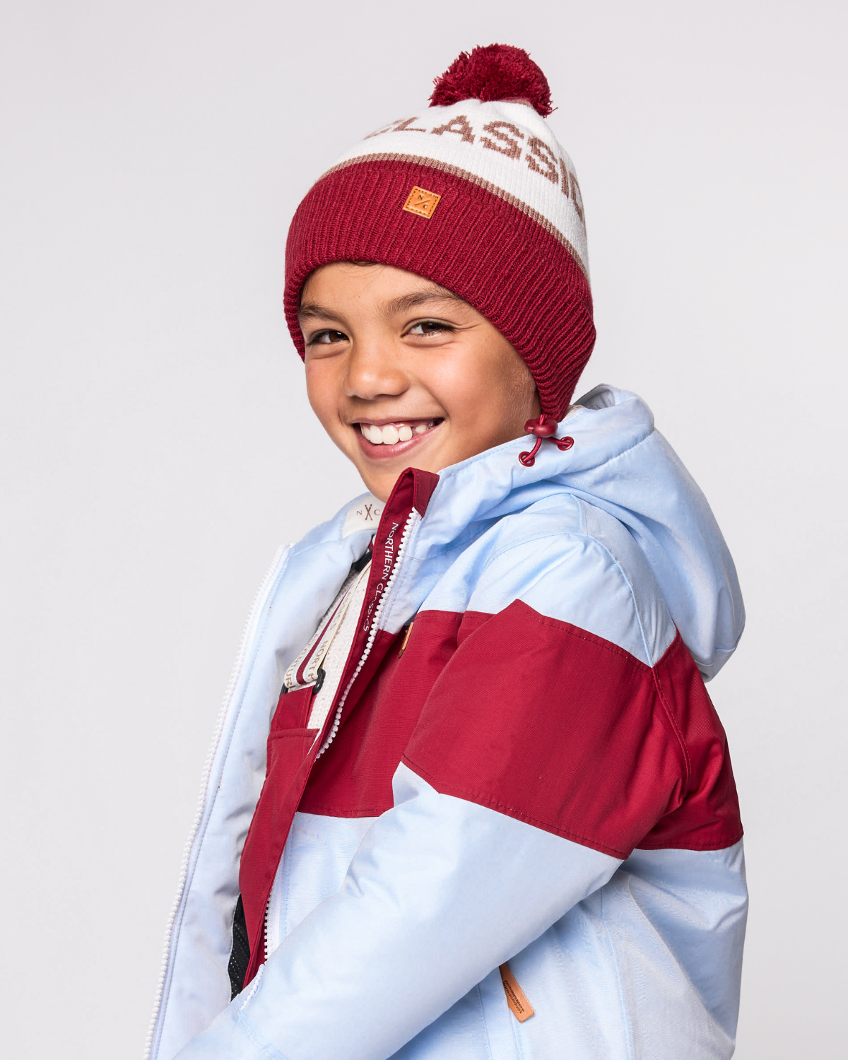 Classic Knit Pom Pom Hat for Kids and Women’s sizes in red, brown, and white, crafted with soft knit fabric, luxe faux fur pom detail, and winter-ready durability for everyday adventures. It's so soft it feels like cashmere.