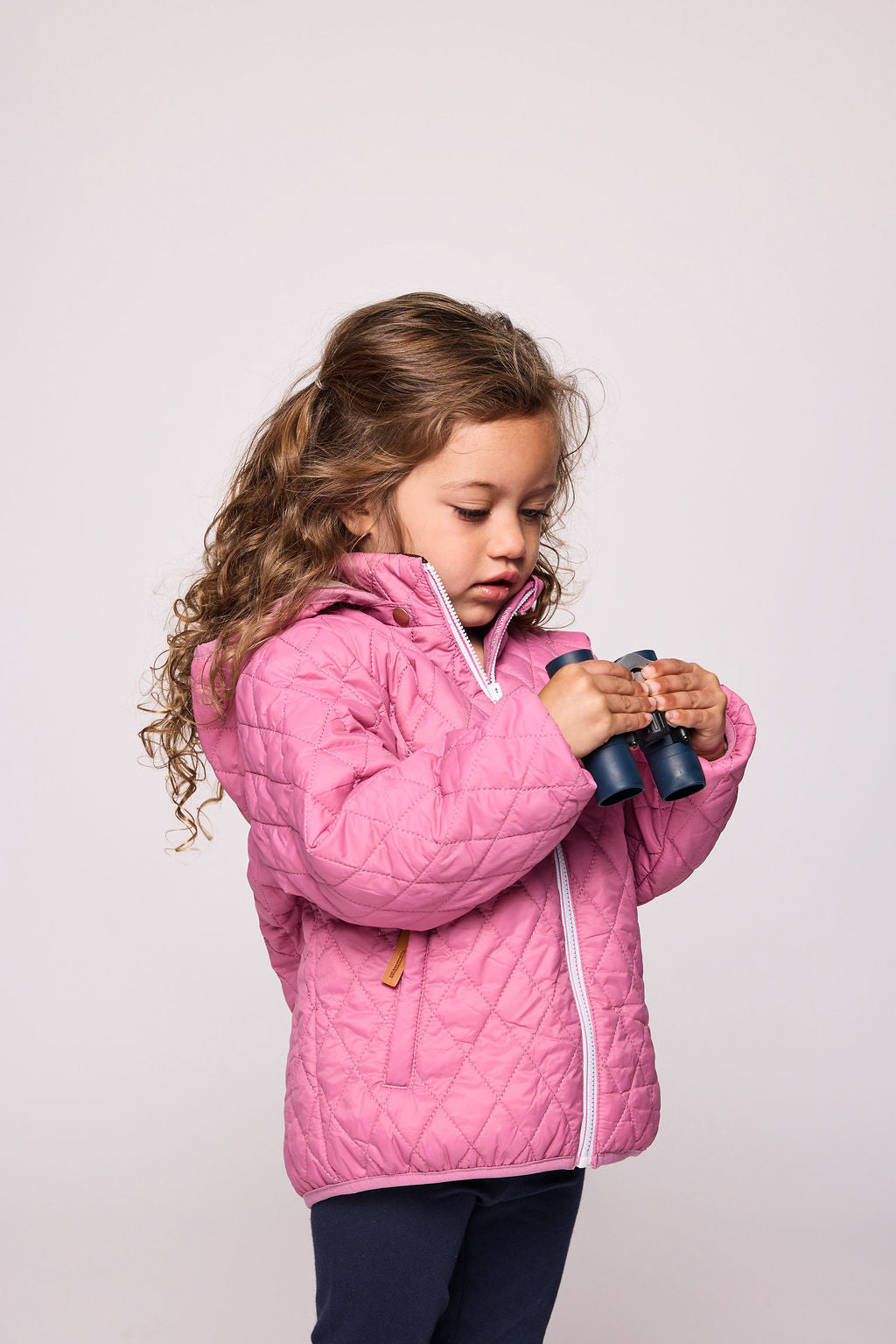Girls and women pink puffer jacket for fall and winter, designed as a warm in-between layer with removable hood, insulated core, and water-resistant fabric