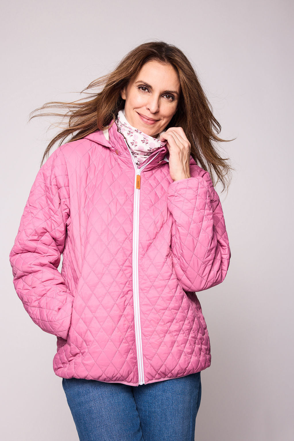 Women's pink puffer jacket for fall and winter with removable hood, insulated lining, and water-resistant outer shell