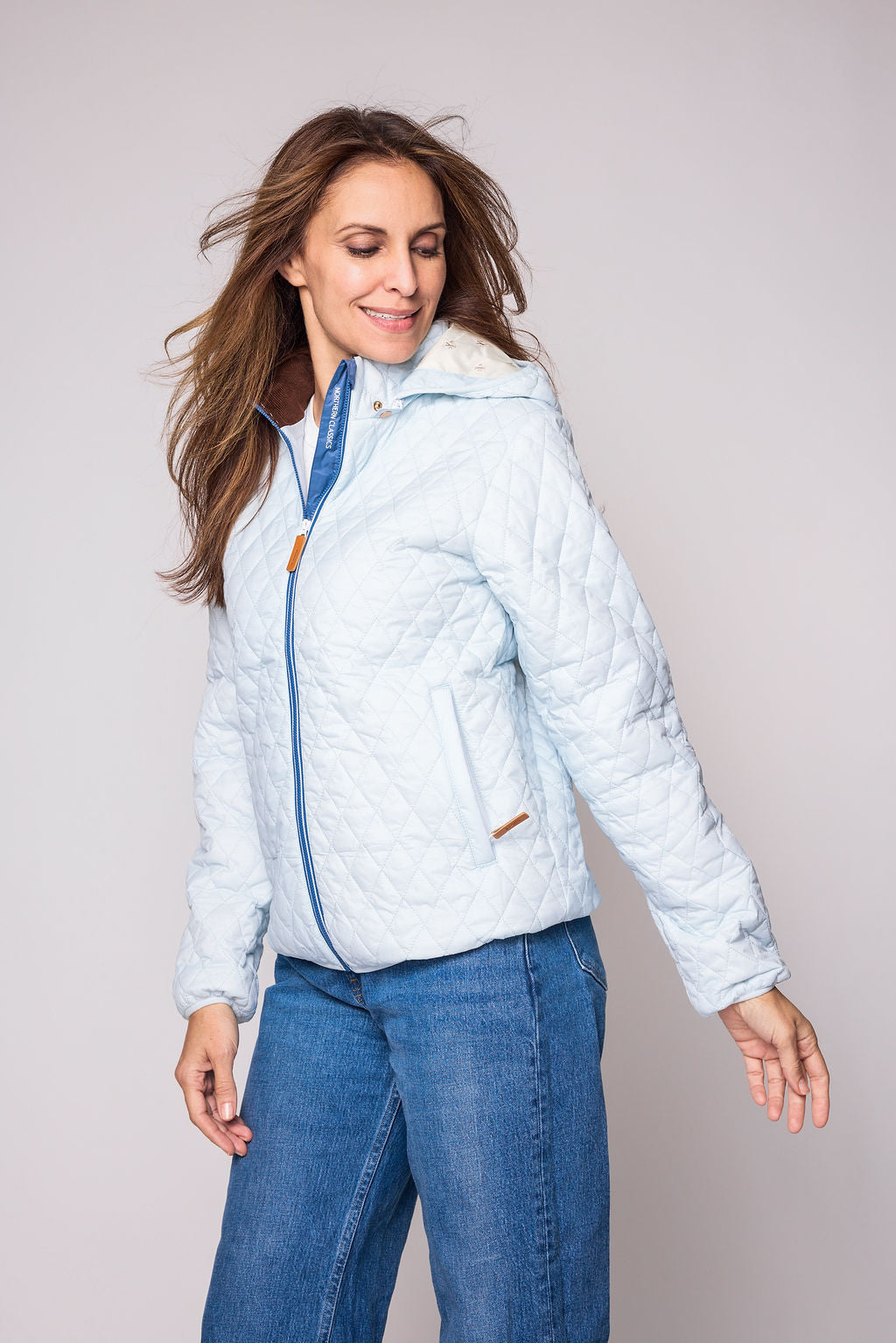 Women's light blue puffer jacket for fall and winter with removable hood, insulated lining, and water-resistant outer shell