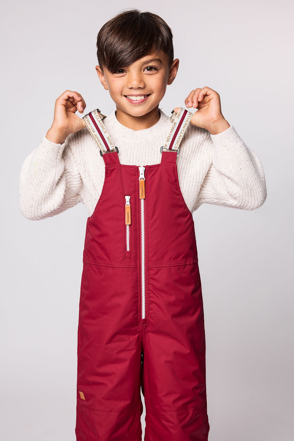 Kids red snow bib pants with adjustable straps, waterproof fabric, and reinforced knees for winter play and ski