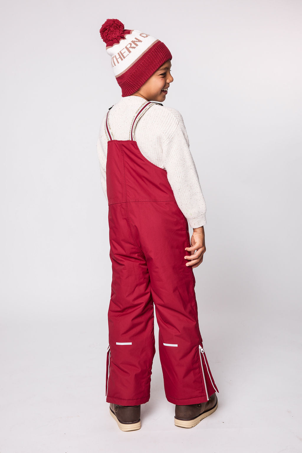 Kids red snow bib pants with adjustable straps, waterproof fabric, and reinforced knees for winter play and ski
