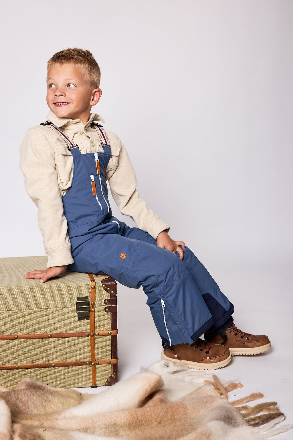 Kids blue snow bib pants with adjustable straps, waterproof fabric, and reinforced knees for winter play