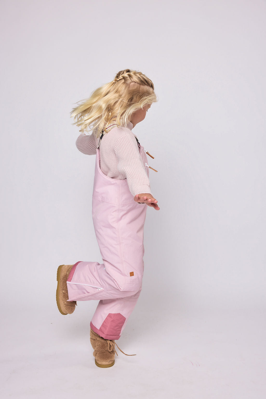 Kids light pink snow bib pants with adjustable straps, waterproof fabric, and reinforced knees for winter play and ski for girls