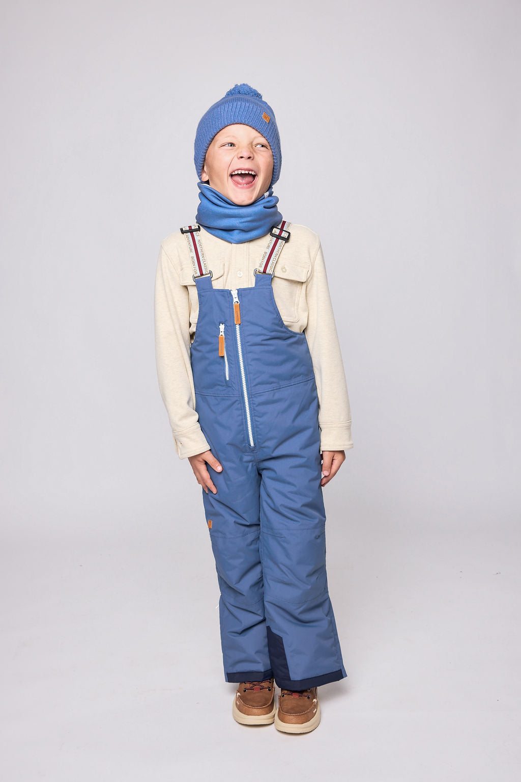 Kids blue snow bib pants with adjustable straps, waterproof fabric, and reinforced knees for winter play