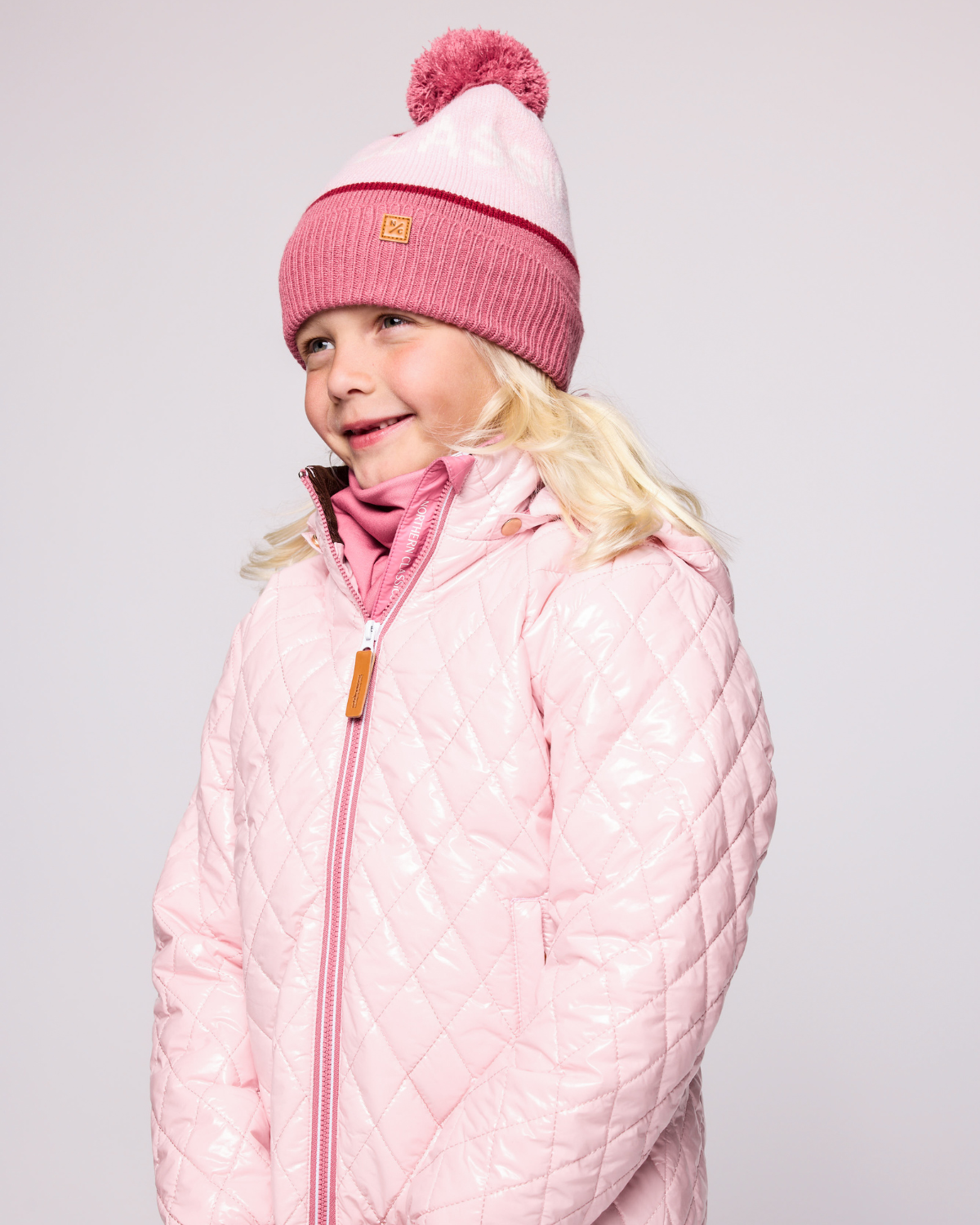 Classic Knit Pom Pom Hat for Kids and Women’s sizes in rose pink, light pink, and red, crafted with soft knit fabric, luxe faux fur pom detail, and winter-ready durability for everyday adventures. It's so soft it feels like cashmere.