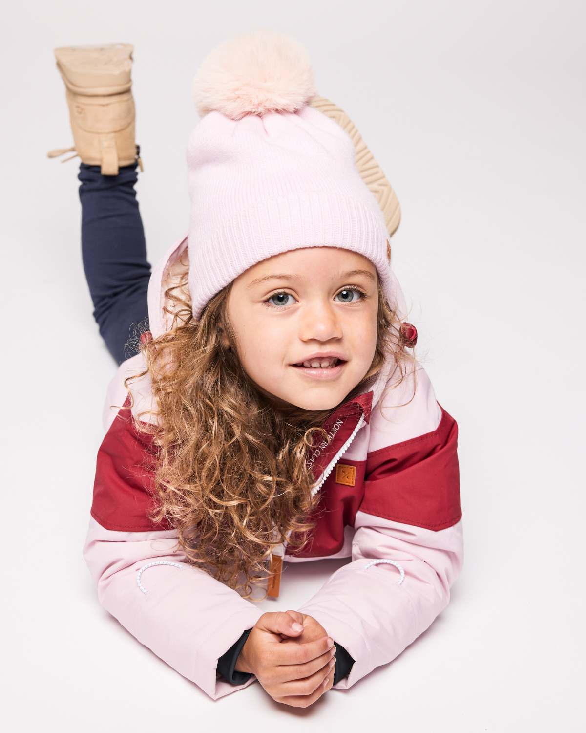 Classic Knit Pom Pom Hat for Kids and Women’s sizes in light pink crafted with soft knit fabric, luxe faux fur pom detail, and winter-ready durability for everyday adventures. It's so soft it feels like cashmere.