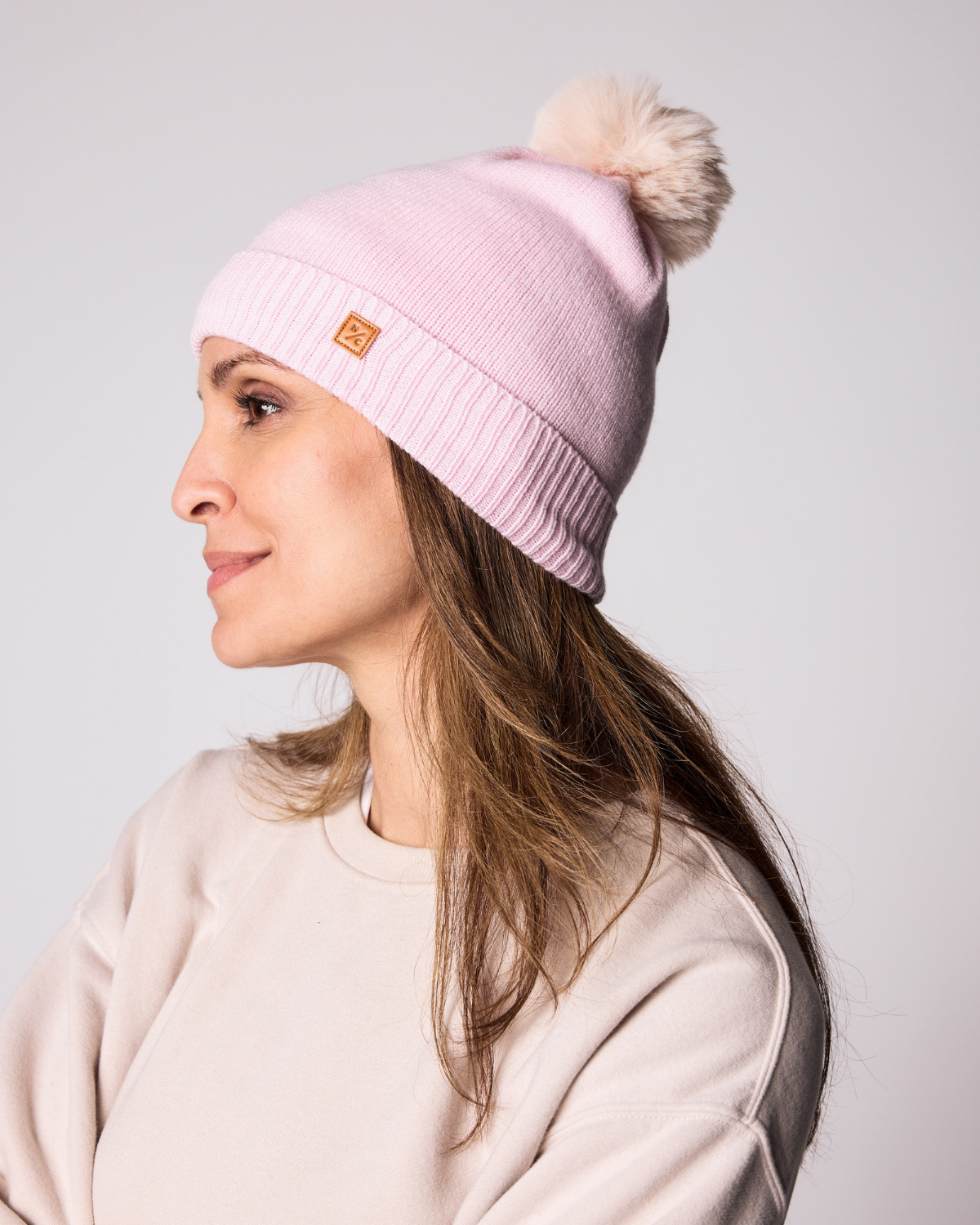 Classic Knit Pom Pom Hat for Kids and Women’s sizes in light pink crafted with soft knit fabric, luxe faux fur pom detail, and winter-ready durability for everyday adventures. It's so soft it feels like cashmere.