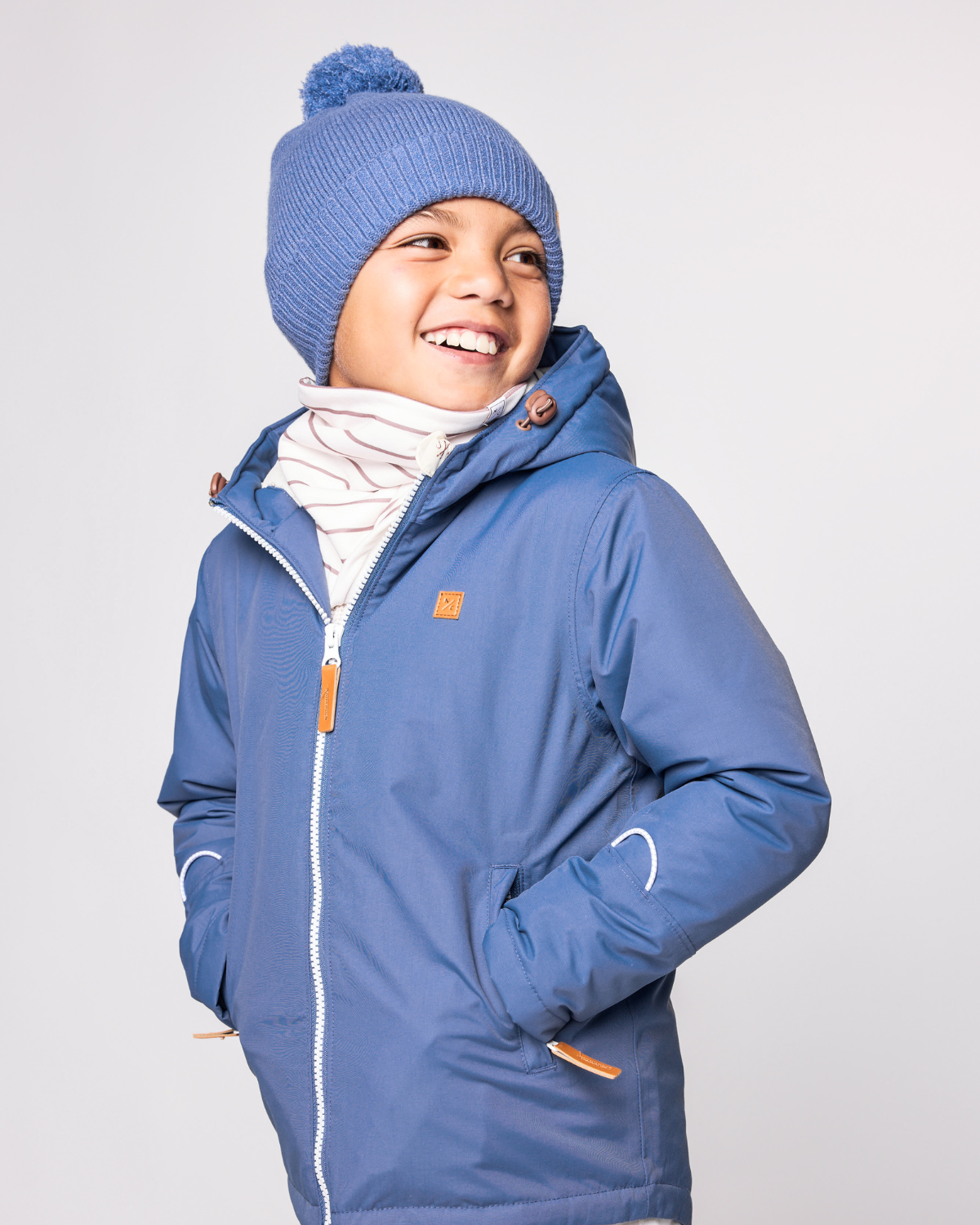 Classic Knit Pom Pom Hat for Kids and Women’s sizes in blue crafted with soft knit fabric, luxe faux fur pom detail, and winter-ready durability for everyday adventures. It's so soft it feels like cashmere.