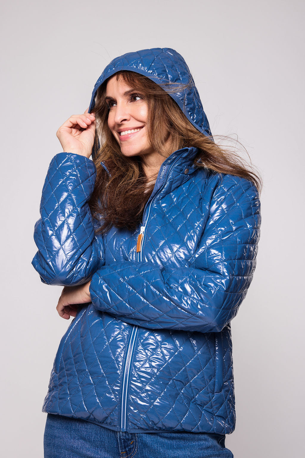 Women's shiny blue puffer jacket for fall and winter with removable hood, insulated lining, and water-resistant outer shell