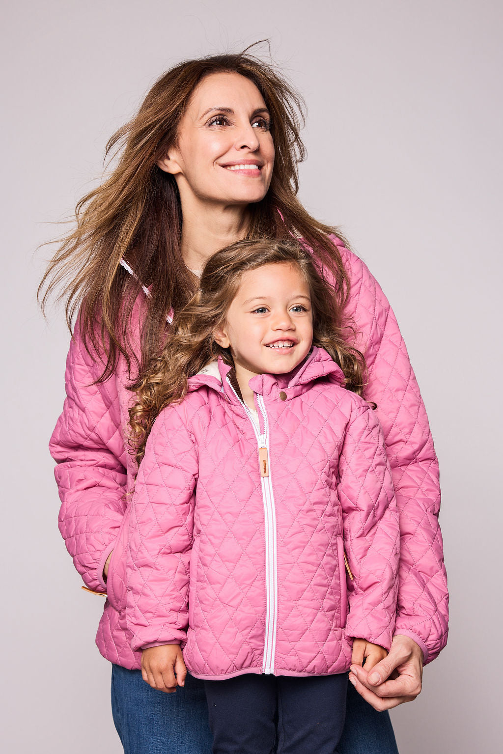 Girls and women pink puffer jacket for fall and winter, designed as a warm in-between layer with removable hood, insulated core, and water-resistant fabric