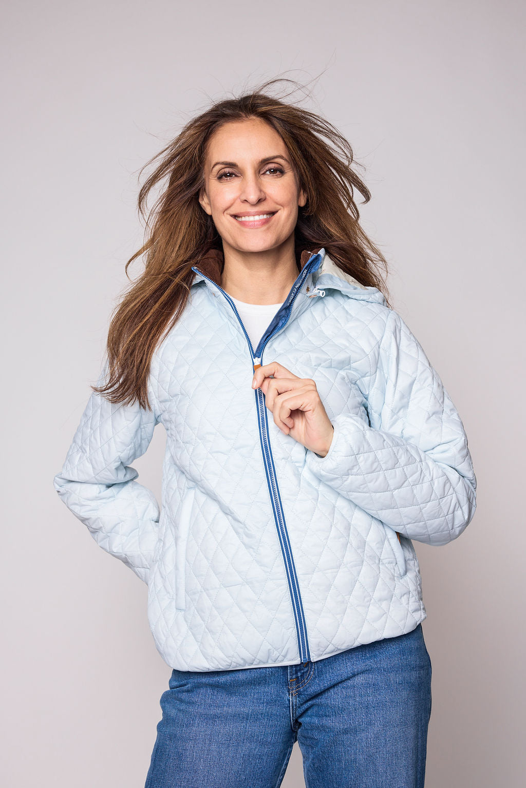 Women's light blue puffer jacket for fall and winter with removable hood, insulated lining, and water-resistant outer shell