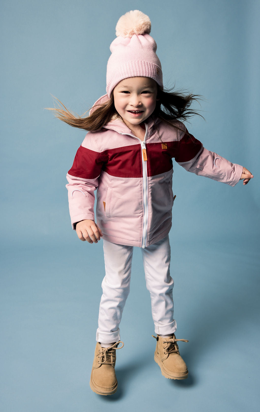 Kids red and light pink winter coat for skiing and snow play, with warm insulation and waterproof outer shell for full cold weather protection and hood