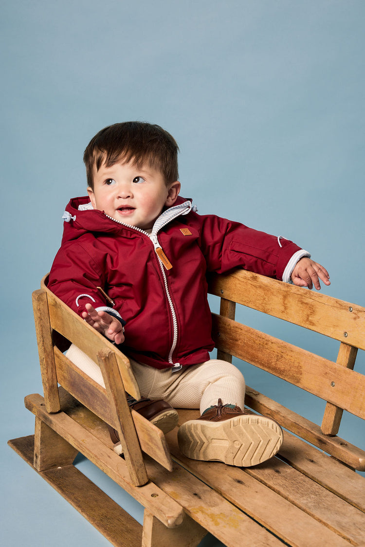Kids red winter coat for skiing and snow play, with warm insulation and waterproof outer shell for full cold weather protection and hood