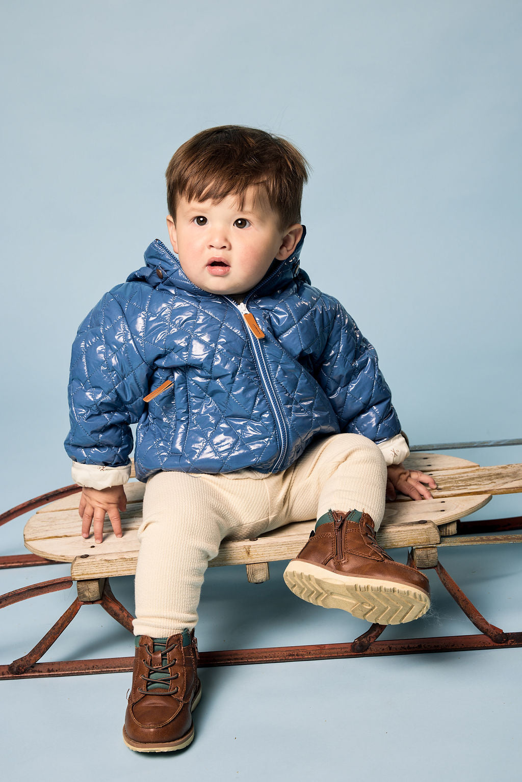 Kids and women shiny blue puffer jacket for fall and winter, designed as a warm in-between layer with removable hood, insulated core, and water-resistant fabric