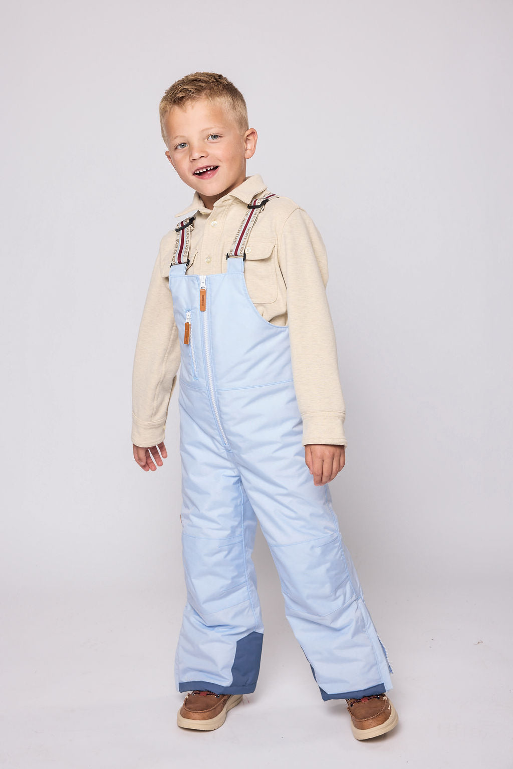 Kids light blue snow bib pants with adjustable straps, waterproof fabric, and reinforced knees for winter play and ski