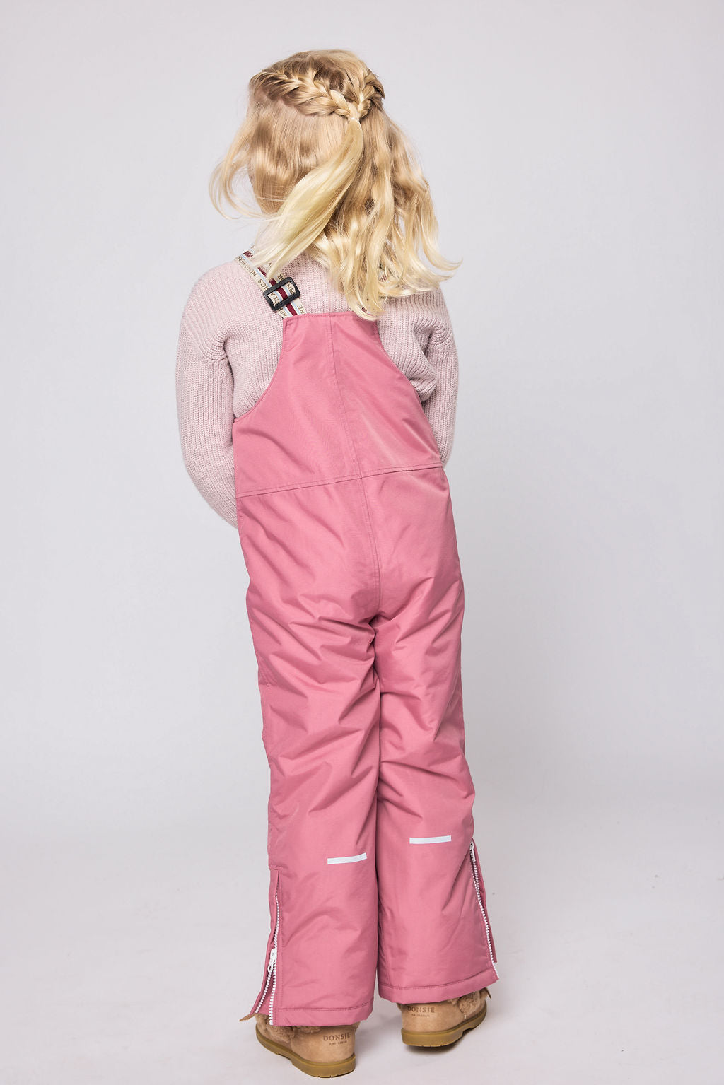 Kids pink snow bib pants with adjustable straps, waterproof fabric, and reinforced knees for winter play and ski for girls