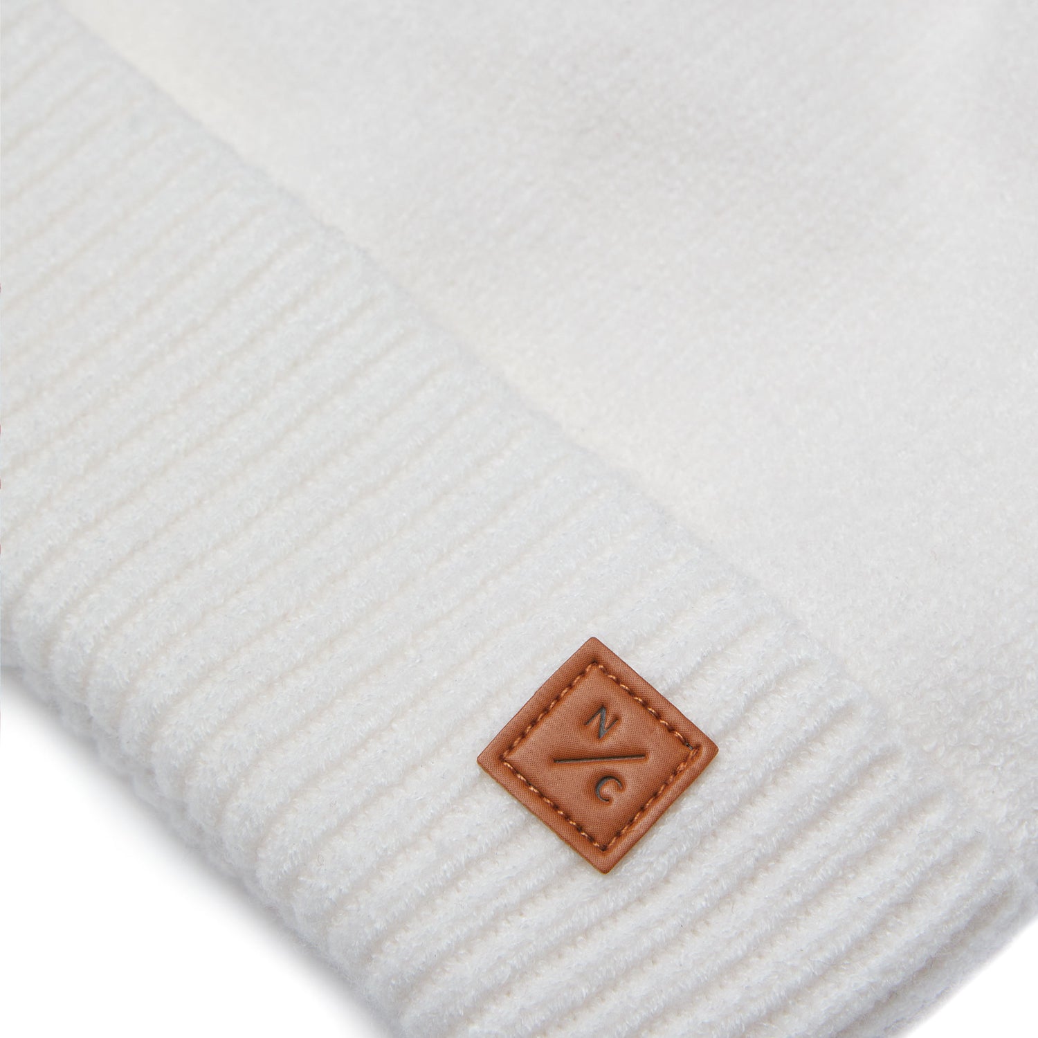 Classic Knit Pom Pom Hat for Kids and Women’s sizes in beige white crafted with soft knit fabric, luxe faux fur pom detail, and winter-ready durability for everyday adventures. It's so soft it feels like cashmere.