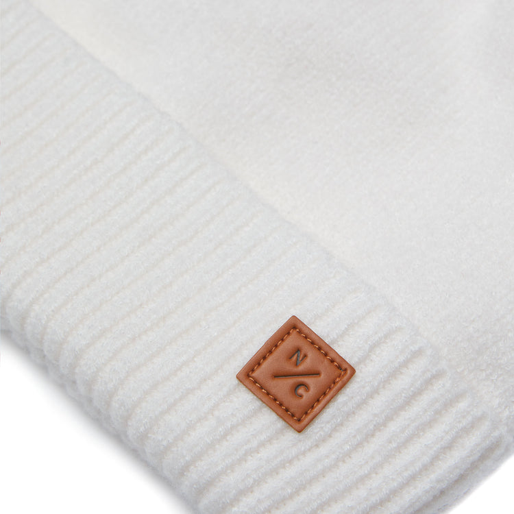Classic Knit Pom Pom Hat for Kids and Women’s sizes in beige white crafted with soft knit fabric, luxe faux fur pom detail, and winter-ready durability for everyday adventures. It's so soft it feels like cashmere.