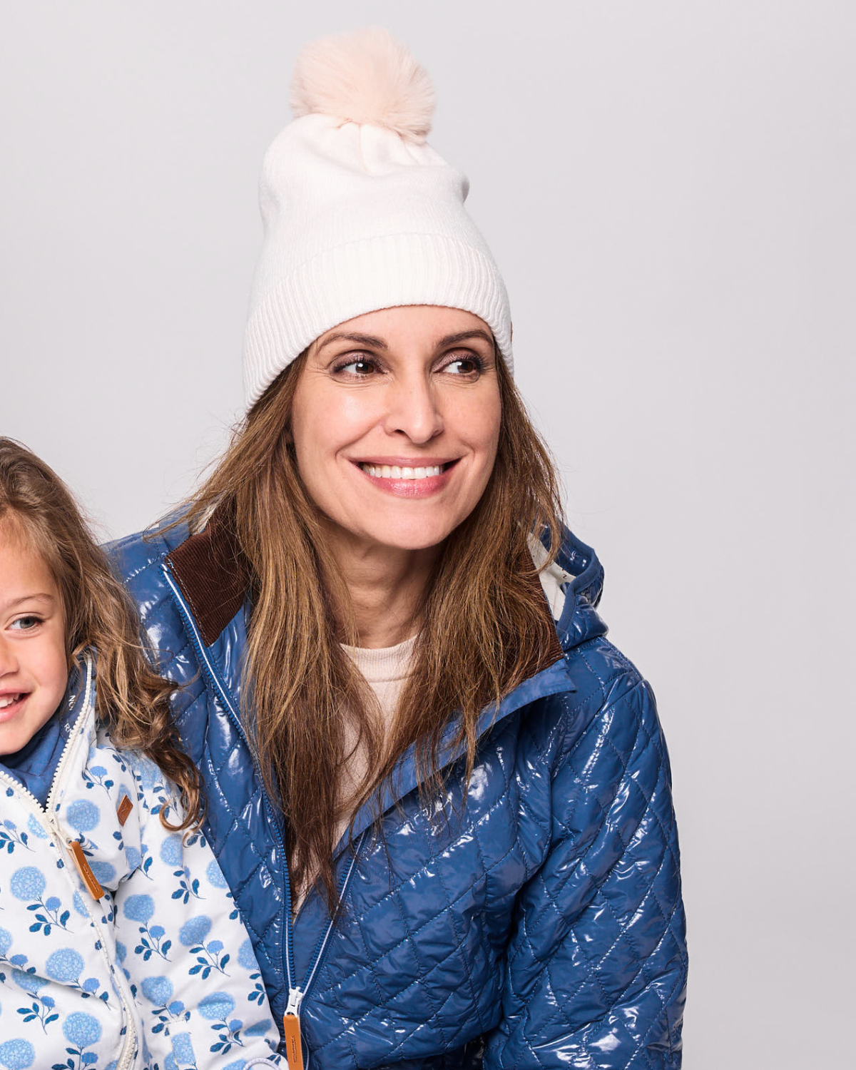 Classic Knit Pom Pom Hat for Kids and Women’s sizes in beige white crafted with soft knit fabric, luxe faux fur pom detail, and winter-ready durability for everyday adventures. It's so soft it feels like cashmere.